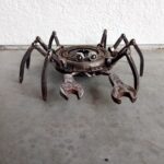 Kovová socha kraba z recyklovaných materiálů – tělo z přítlačného kotouče, klepeta z klíčů, nohy z čtyřhranných tyčí.